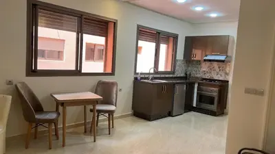 a kitchen with a table and two chairs and a table and a table and chairs at Appartement de haute standing in Marrakech