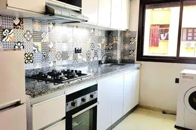a kitchen with white cabinets and a stove top oven at Marrakech appart in Marrakech