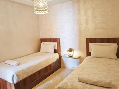 a bedroom with two beds and a chandelier at Marrakech appart in Marrakech