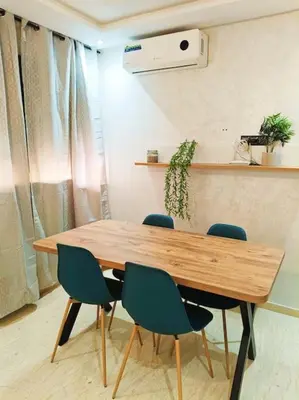 a wooden table with four chairs in a room at Marrakech appart in Marrakech