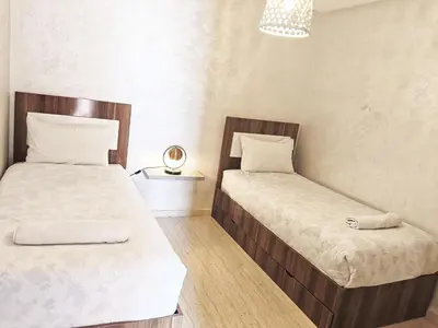 two twin beds in a room with a lamp at Marrakech appart in Marrakech