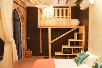 a bedroom with a bunk bed and a room with a ladder at Riad 10 Mandarin BOUTIQUE RIAD in Marrakech