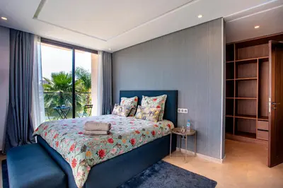 a bedroom with a blue bed and a window at Villa Argana moderne et luxueuse piscine chauffée in Marrakech