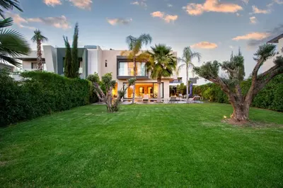 a large yard in front of a house with palm trees at Villa Argana moderne et luxueuse piscine chauffée in Marrakech