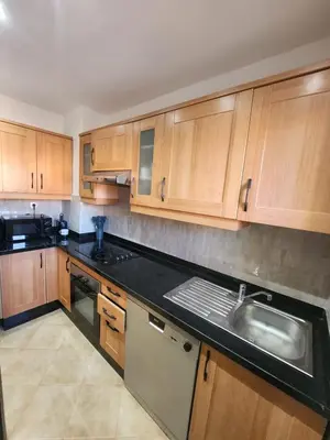 a kitchen with wooden cabinets and a sink at Dar Atlas Lula in Marrakech