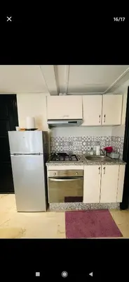 a kitchen with white cabinets and a white refrigerator at Marrakesh in Marrakech