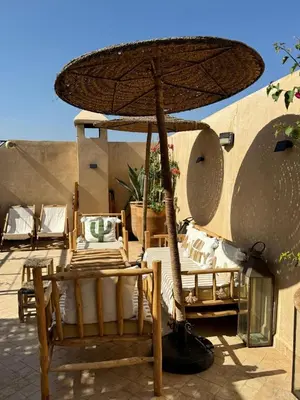 a table and chairs under an umbrella on a patio at Riad dar serenity in Marrakech