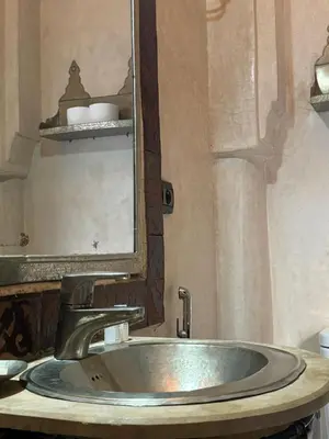 a bathroom sink with a large mirror above it at Riad dar serenity in Marrakech