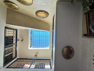 a hallway with a window and a door with lights at Riad dar serenity in Marrakech