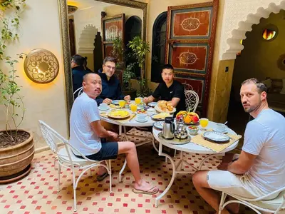 a group of men sitting at a table eating food at Riad dar serenity in Marrakech