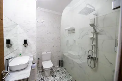 a white bathroom with a shower and a toilet at Jawhar Appart A3 in Marrakech