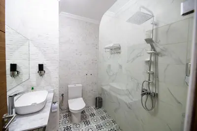 a white bathroom with a shower and a toilet at Jawhar Appart A3 in Marrakech