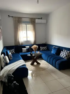 a blue couch in a living room with a table at Portes de Marrakech in Marrakech