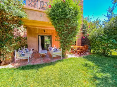 a patio with chairs and a table in a yard at Hamza immobiler in Marrakech