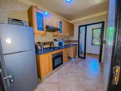 a kitchen with wooden cabinets and a stainless steel refrigerator at Hamza immobiler in Marrakech