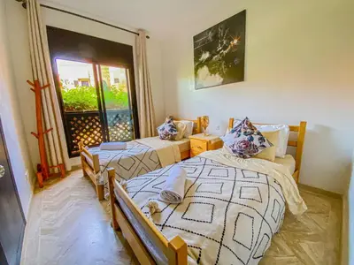 a bedroom with two beds and a window at Hamza immobiler in Marrakech