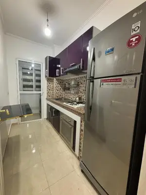 a kitchen with a stainless steel refrigerator and purple cabinets at Marrakech menara in Marrakech