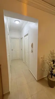 a hallway with two white doors and a potted plant at Marrakech menara in Marrakech
