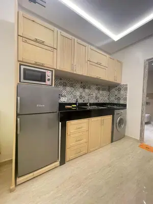 a kitchen with a refrigerator and a microwave at Appartement Neuf et Moderne in Marrakech