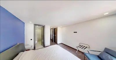 a bedroom with a white bed and a blue wall at Très Beau Duplexe avec piscine depuis la terrasse in Marrakech