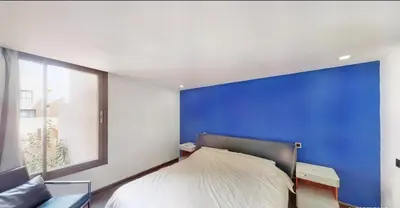a bedroom with a blue wall and a bed at Très Beau Duplexe avec piscine depuis la terrasse in Marrakech