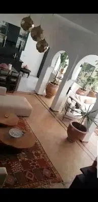 a living room with two potted plants on the floor at Villa Bohème Havre de paix, piscine chauffée,4 Suites in Marrakech
