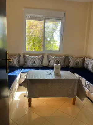 a living room with a couch with a table and a window at Appartement in Marrakech