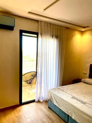 a bedroom with a bed and a window with a balcony at Stylish Apartment IN Marrakech E25 in Marrakech