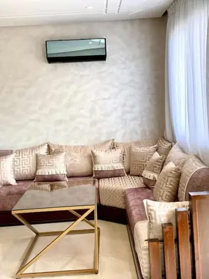 a living room with a couch and a tv on the wall at Stylish Apartment IN Marrakech E25 in Marrakech