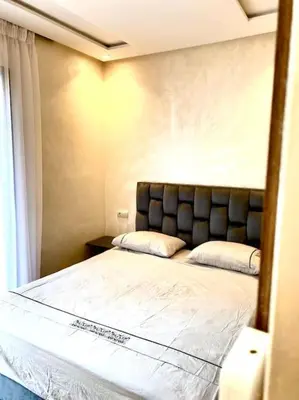 a bedroom with a bed with a headboard and a window at Stylish Apartment IN Marrakech E25 in Marrakech