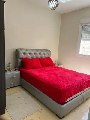a bedroom with a large bed with red pillows at Appartement in Marrakech
