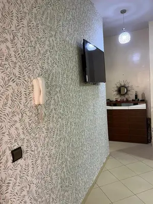 a room with a wall with a phone and a tv at Appartement in Marrakech