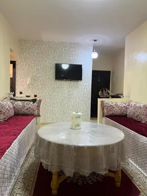 a room with a table and a tv on a wall at Appartement in Marrakech