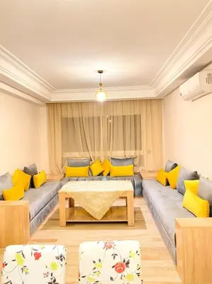 a living room with a couch and yellow pillows at Apartment Comfortable Marrakech in Marrakech