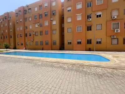 an empty swimming pool in front of a building at Issam appart in Marrakech