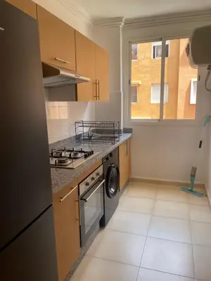 a kitchen with a stove top oven next to a window at Issam appart in Marrakech