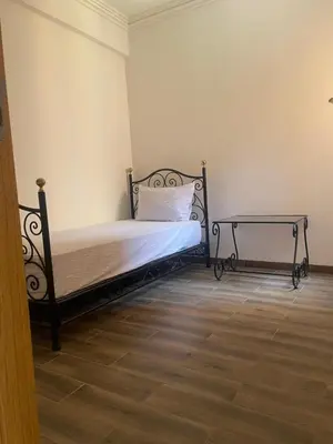 a bedroom with a bed and a side table at Issam appart in Marrakech