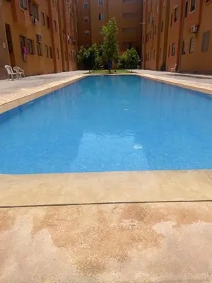 a large blue swimming pool in a building at Issam appart in Marrakech
