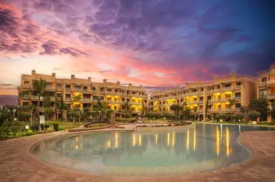 a hotel with a large pool in front of a building at Appartement cosy Piscine et chill in Marrakech