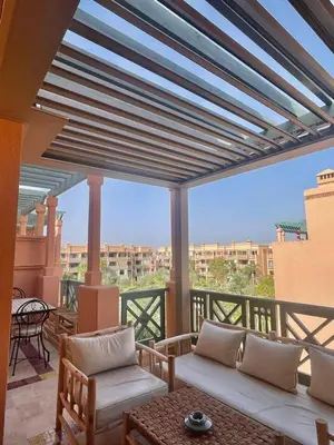 a balcony with a couch and chairs on a balcony at Appartement cosy Piscine et chill in Marrakech