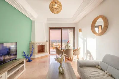 a living room with a couch and a table at Appartement cosy Piscine et chill in Marrakech