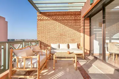 a patio with chairs and a table on a balcony at Appartement cosy Piscine et chill in Marrakech