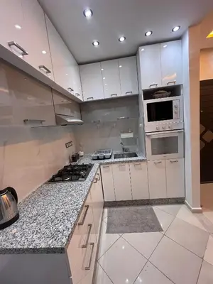 a large kitchen with white cabinets and appliances at Appartement Rénové avec Style et Parking surveillé in Marrakech