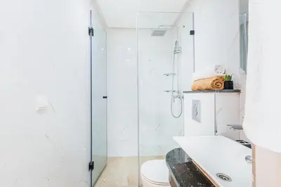 a white bathroom with a shower and a toilet at Migdal Gueliz Apart Hôtel in Marrakech