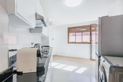 a kitchen with white appliances and a window at Migdal Gueliz Apart Hôtel in Marrakech