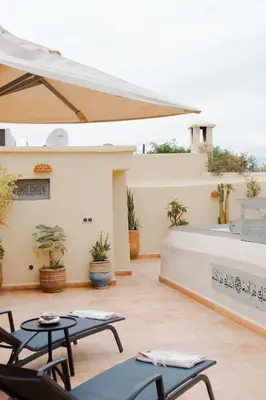 a patio with tables and chairs in front of a building at Boutique Hotel La Maison dArts et Medicine in Marrakech