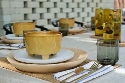 a table topped with yellow cups and plates and silverware at Villa Saman in Marrakech