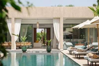 a resort with a swimming pool with chairs and tables at Villa Netumia in Marrakech