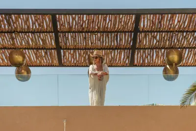 a woman in a hat standing on top of a building at Villa Eyline Amelkis Golf in Marrakech