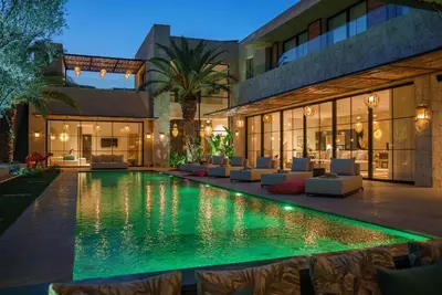 a house with a swimming pool in front of a building at Villa Eyline Amelkis Golf in Marrakech